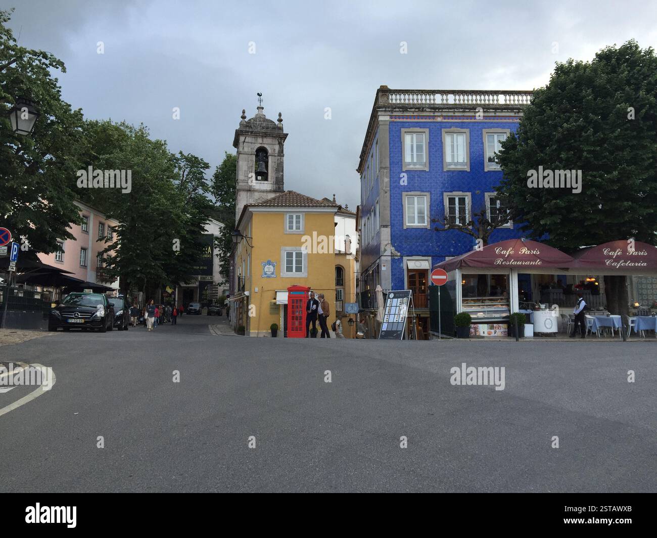 Palais national de Sintra. Bâtiment bleu avec garniture blanche et fenêtres cintrées. Bâtiment jaune avec une tour de l'horloge. Cabine téléphonique britannique rouge. Panneau Café Paris Banque D'Images
