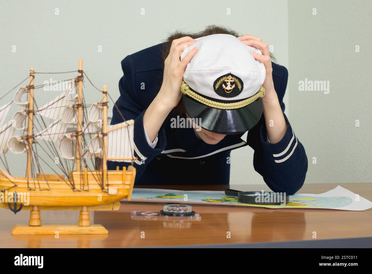 Femme en uniforme de capitaine de mer concentré pense à une carte Banque D'Images