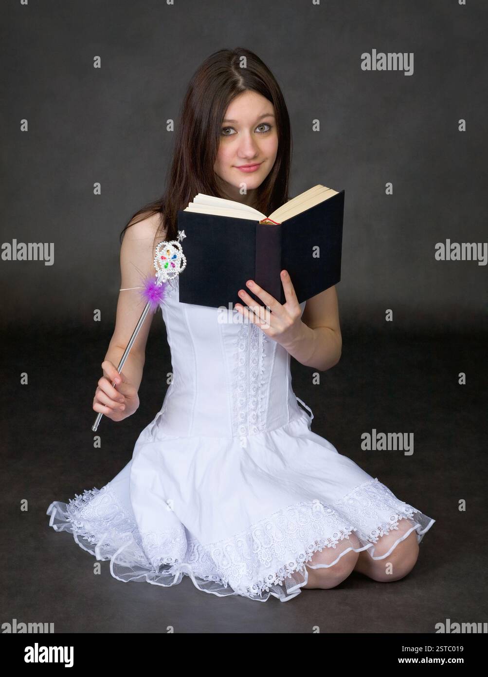 Fille avec le livre et une baguette magique Banque D'Images