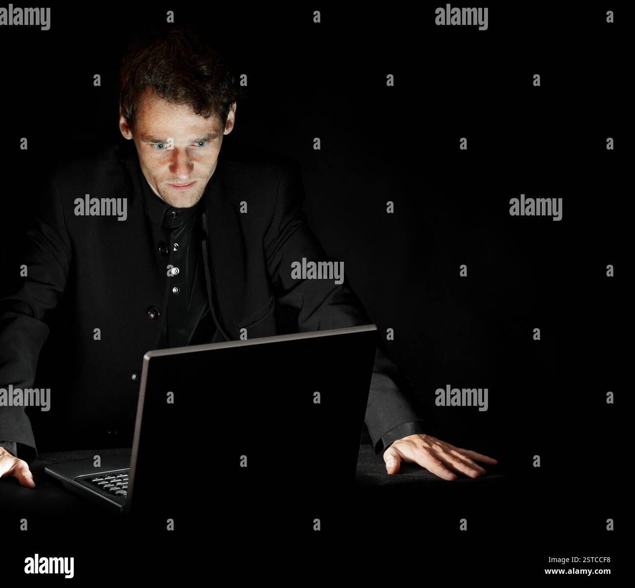 Hacker avec ordinateur portable dans une pièce sombre Banque D'Images