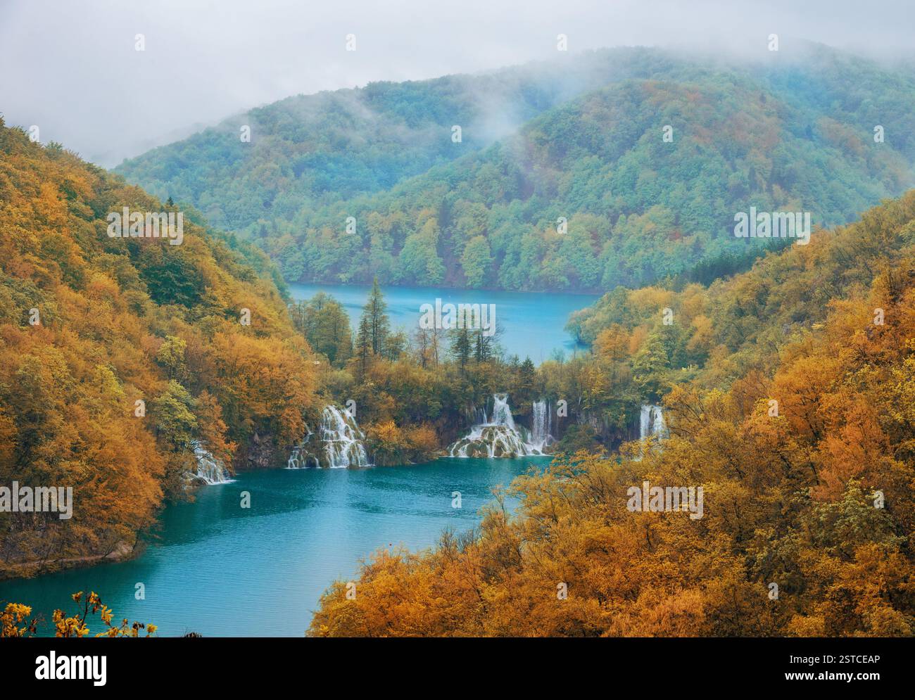 Paysage d'automne brumeux des lacs de Plitvice, Croatie, avec des eaux turquoises, des cascades en cascade et un feuillage d'automne vibrant dans un cadre serein Banque D'Images