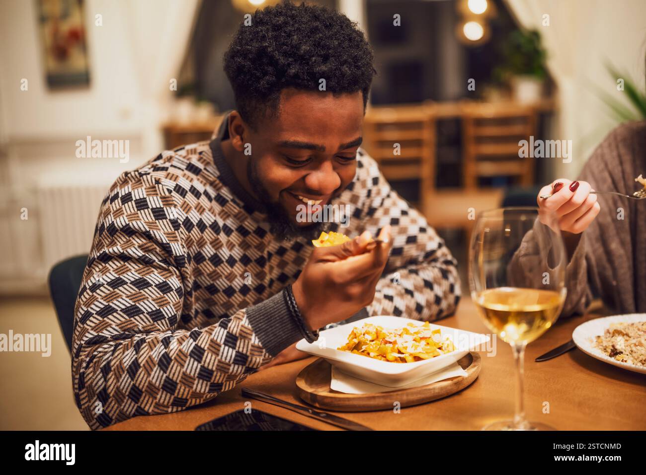 Heureux jeune homme noir dîne et vin au restaurant. Banque D'Images