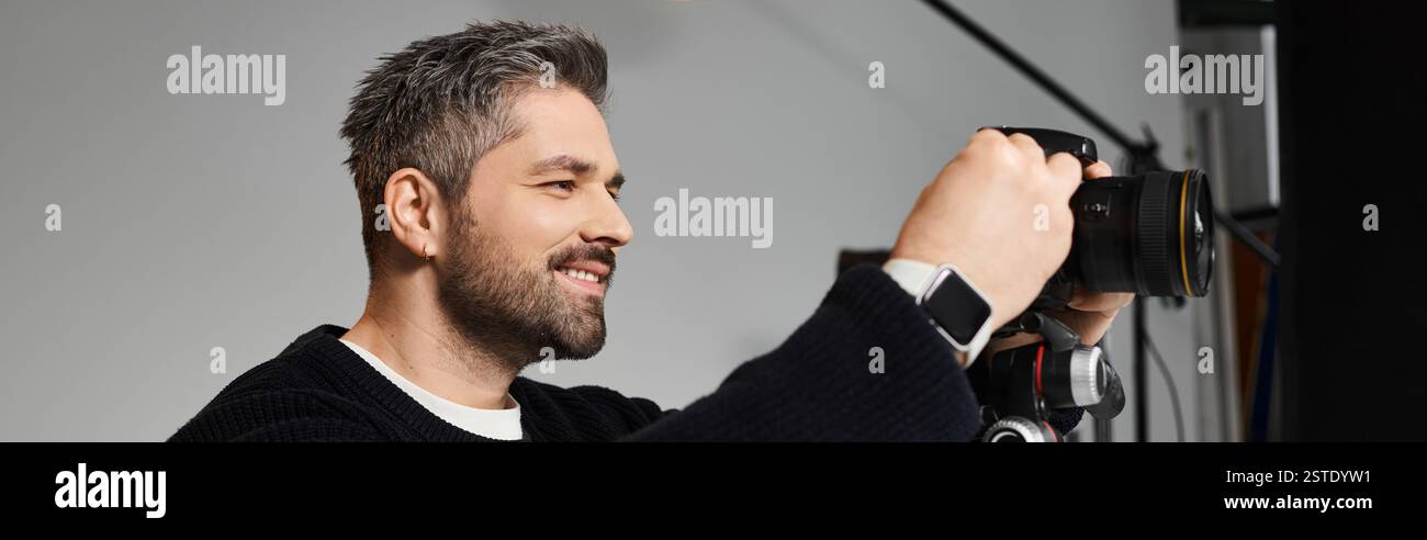 Homme qualifié aime créer des compositions saisissantes tout en travaillant dans une atmosphère de studio dynamique. Banque D'Images