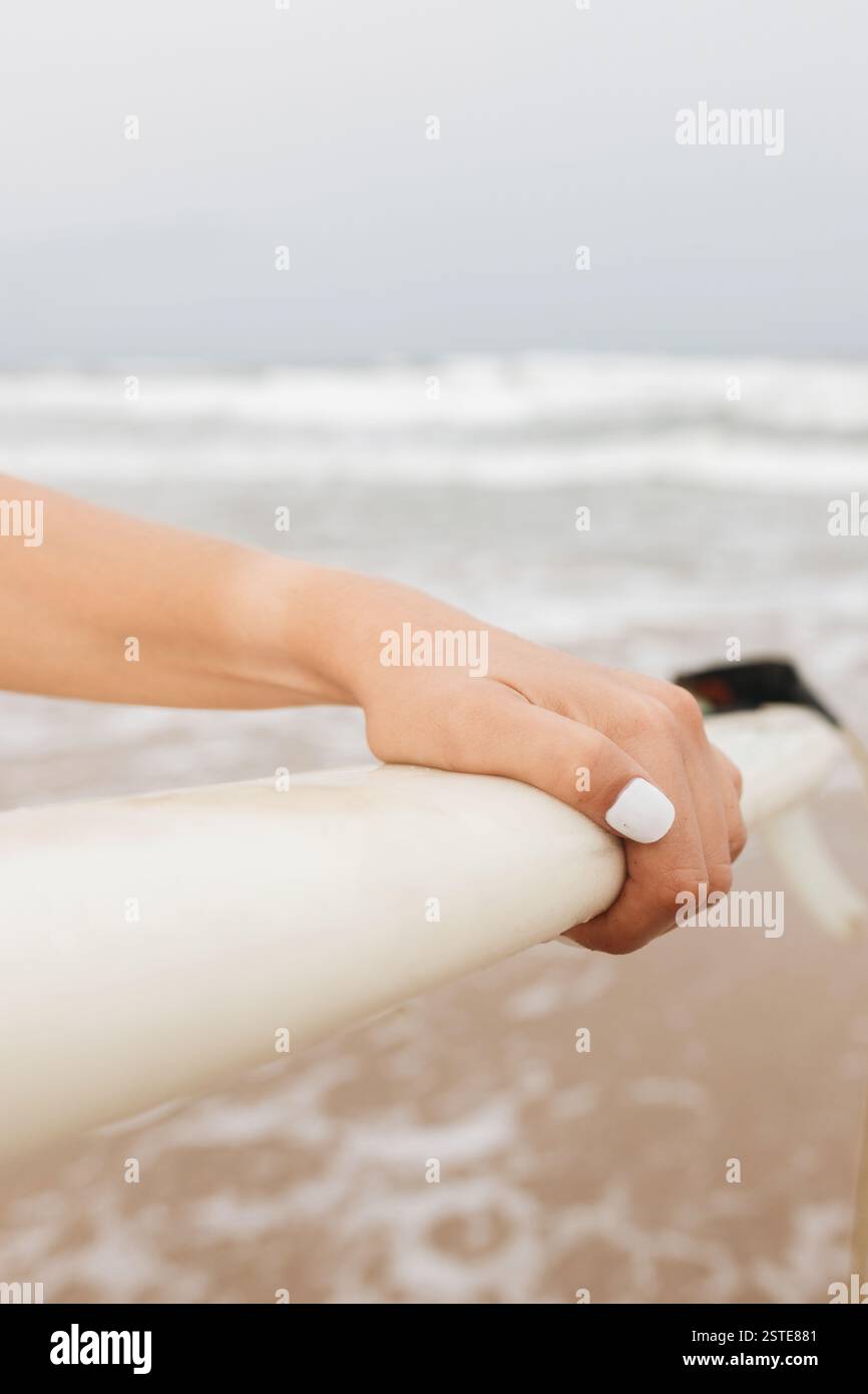 Rognez une athlète féminine méconnue avec une planche de surf à la lumière du jour Banque D'Images