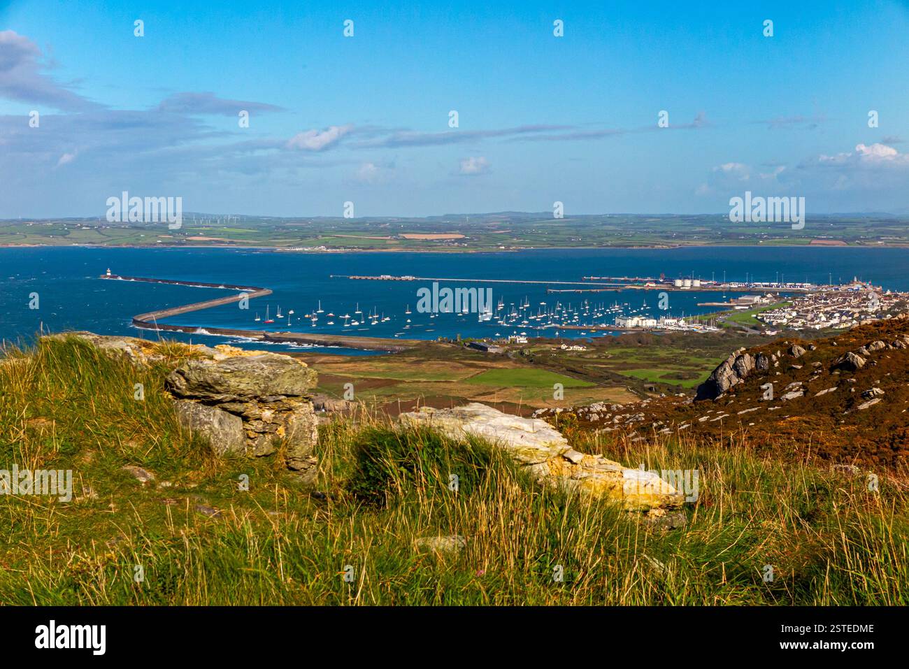 Le littoral et les rochers escarpés regardant vers le bas avec le brise-lames Holyhead visible en arrière-plan sur la côte nord d'Anglesey dans le nord du pays de Galles au Royaume-Uni Banque D'Images
