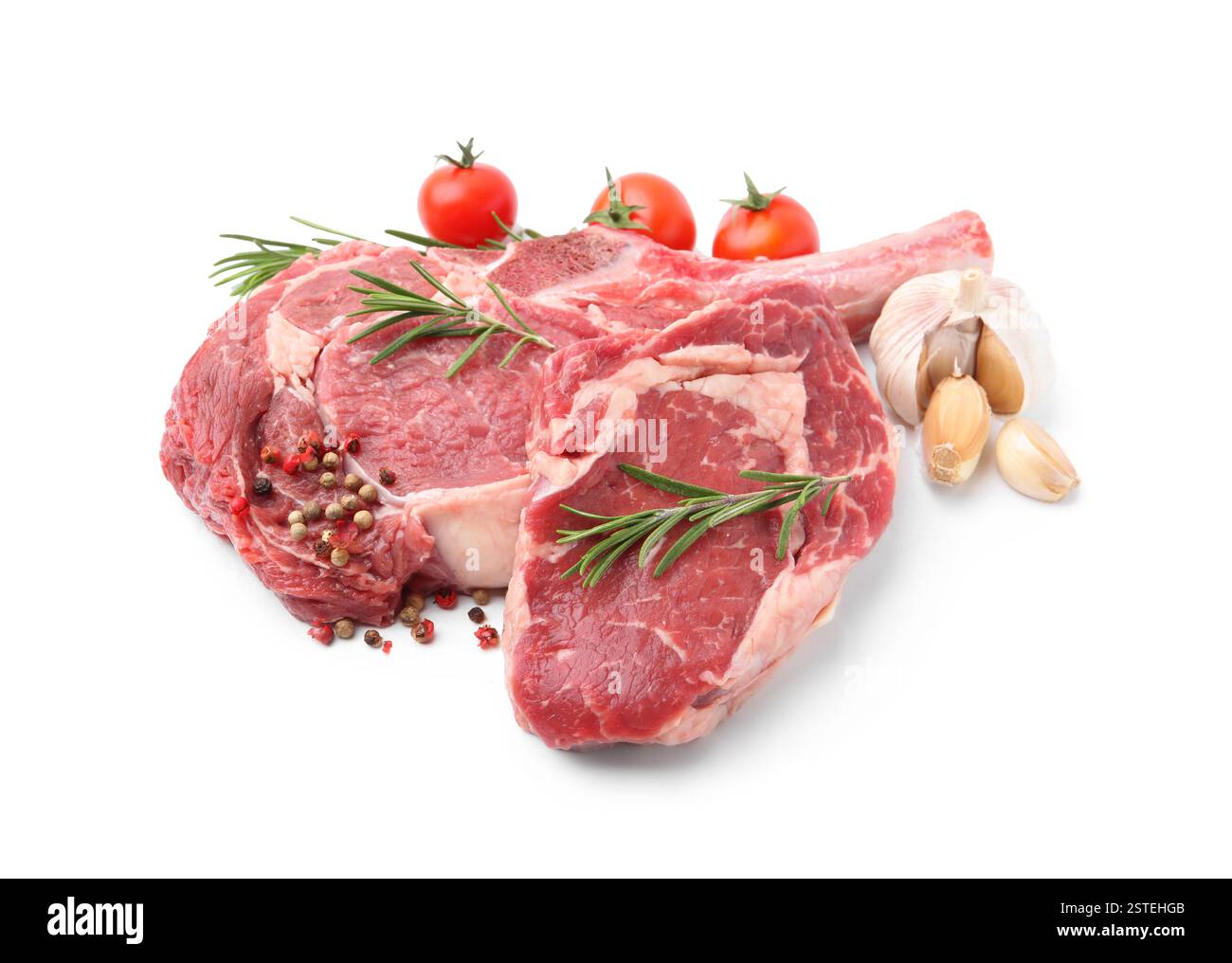 Morceaux de viande de boeuf crue, épices et tomates isolés sur blanc Banque D'Images