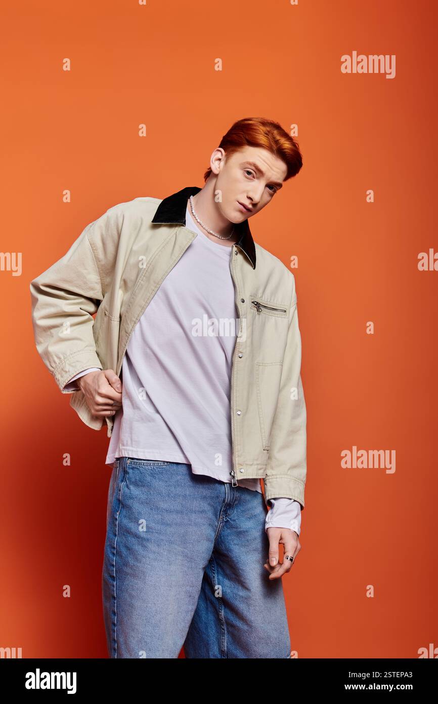 Un homme jeune et beau met en valeur son expression émotionnelle tout en posant dans une tenue décontractée. Banque D'Images