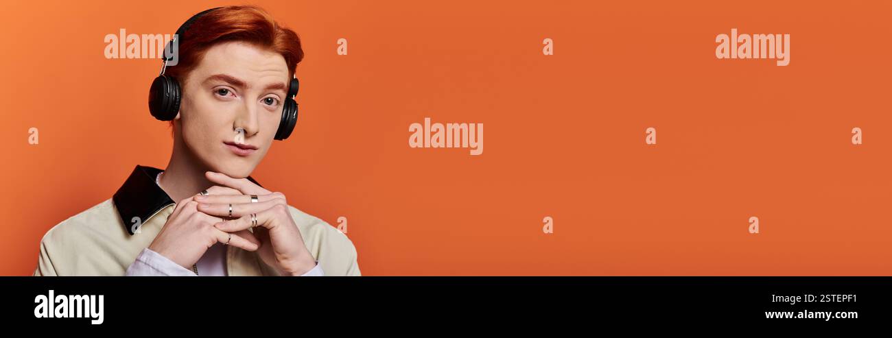 Un homme jeune et beau avec une expression émotionnelle écoute de la musique tout en se relaxant. Banque D'Images