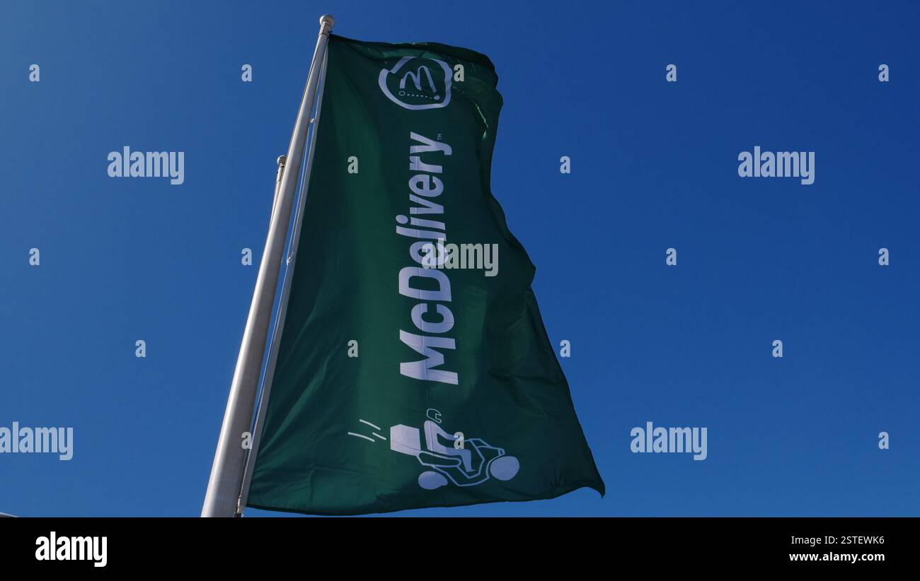 Un drapeau McDelivery devant un restaurant McDonalds au centre commercial Biosfera, Puertol del Carmen, Lanzarote. Banque D'Images