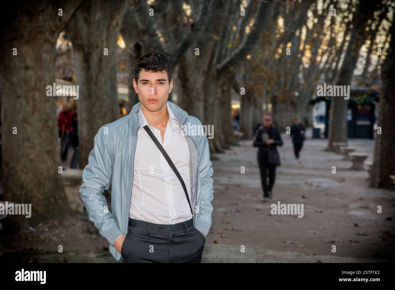 Beau jeune homme dans l'environnement de la ville sous les arbres Banque D'Images