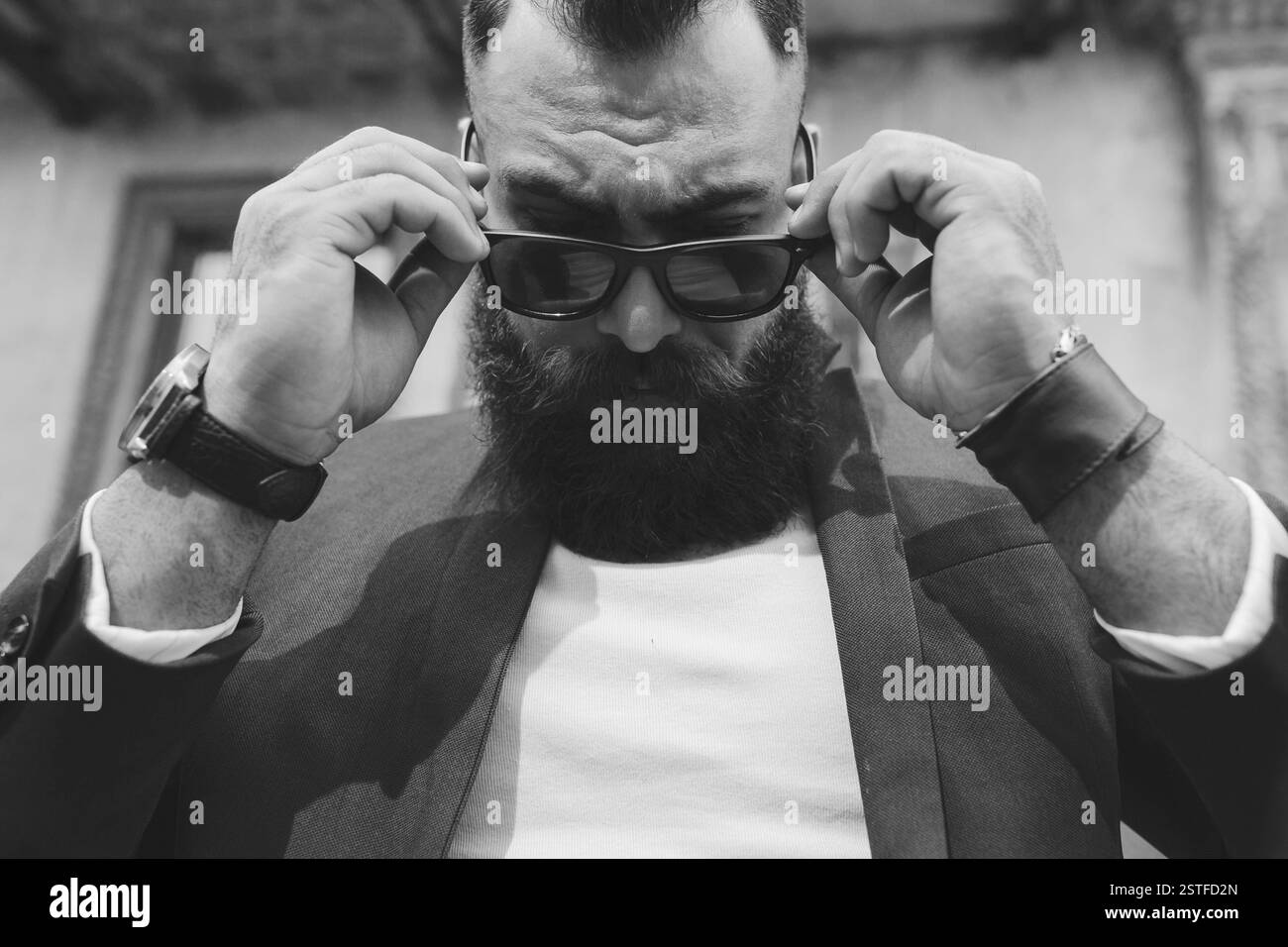 Homme barbu cool élégant enlève ses lunettes Banque D'Images