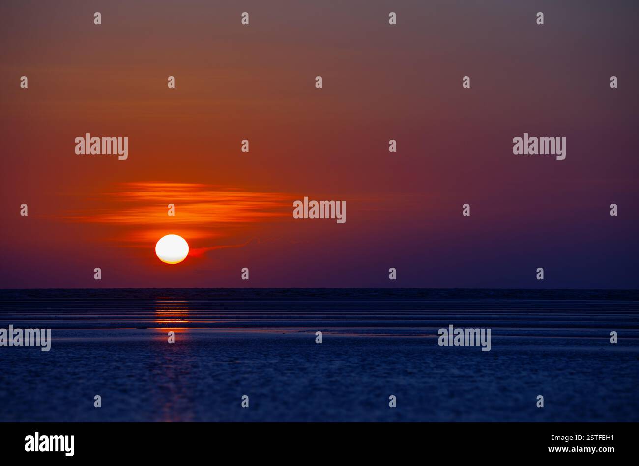 Boule orange du soleil plongeant vers Horizon au coucher du soleil Banque D'Images
