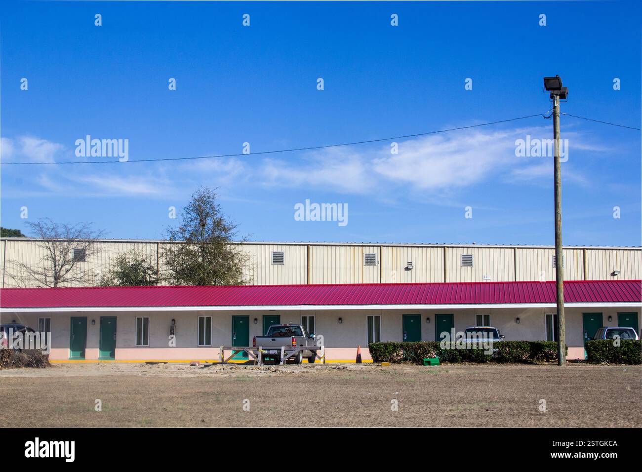 Motel américain classique en Caroline du Nord avec toit rose et portes vertes, évoquant un charme nostalgique en bord de route Banque D'Images