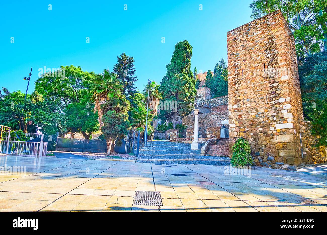 La tour carrée en pierre et le vieux mur de la forteresse Alcazaba Malaga, entouré d'un jardin verdoyant, Malaga, Espagne Banque D'Images