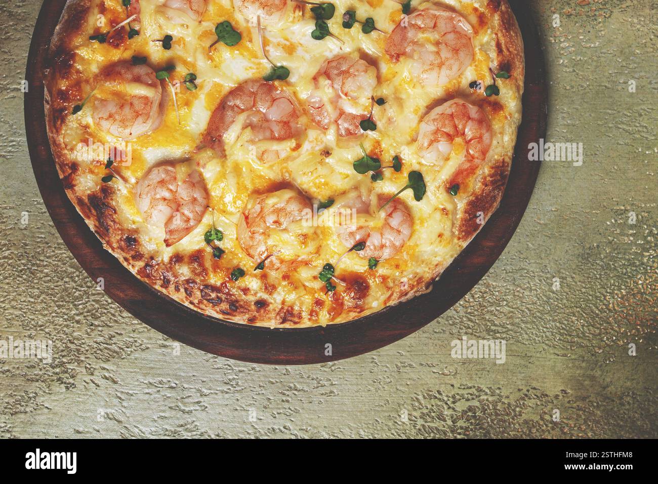 Pizza quatre fromages avec crevettes et microgreens frais, servi sur une planche de bois, fait maison, pas de gens Banque D'Images