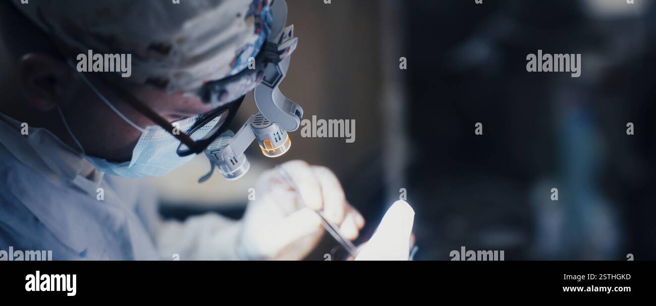 Un chirurgien intensément concentré sur une tâche, portant des loupes pour plus de précision Banque D'Images