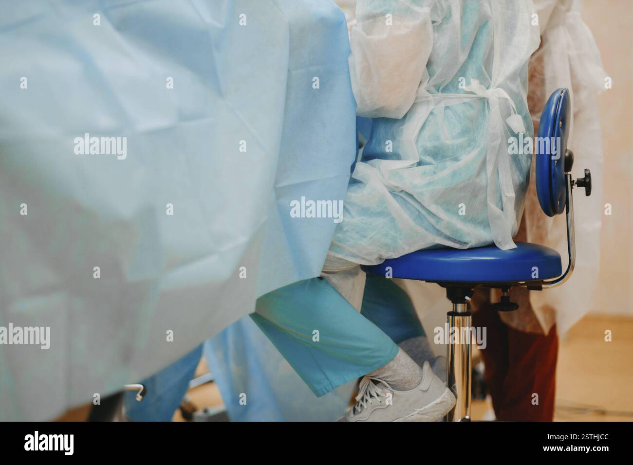 Une équipe médicale en blouse se préparant à une intervention en salle d'opération Banque D'Images