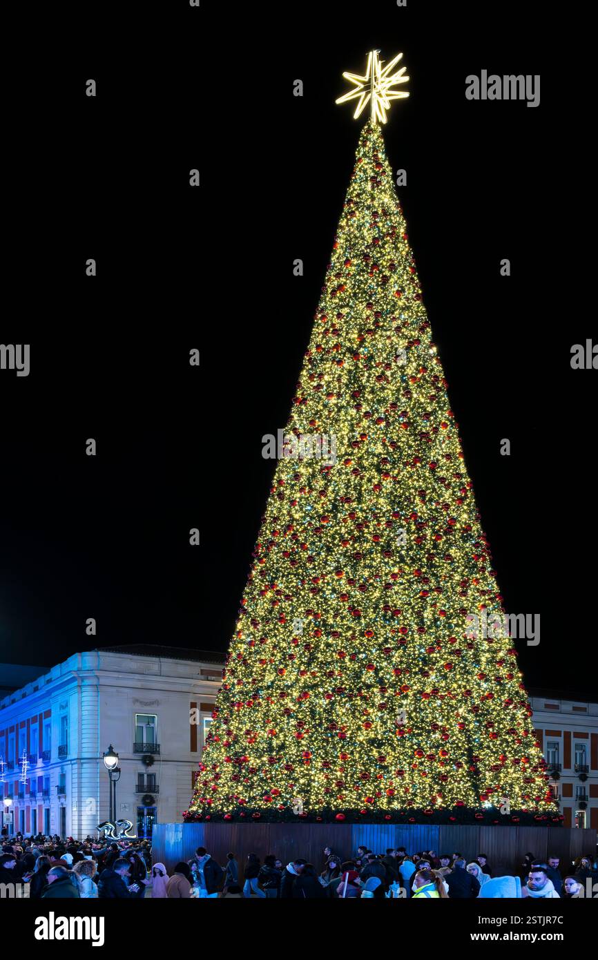 Le sapin de Noël richement décoré de la Puerta del sol situé dans le centre de Madrid. L'arbre doré a des boules rouges et surmonté d'une étoile dorée. Banque D'Images