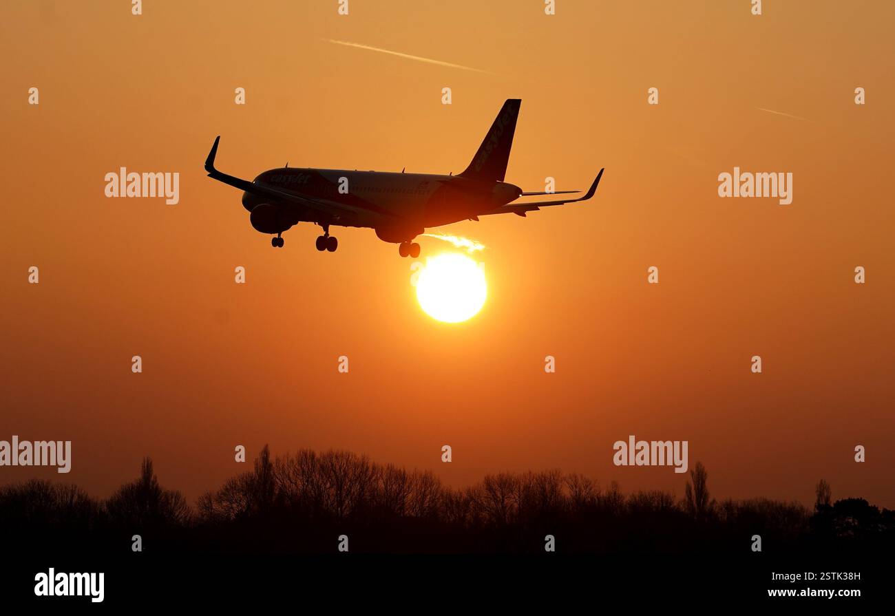 Un avion EasyJet atterrit au lever du soleil à l'aéroport de Londres Gatwick à Crawley, West Sussex. L'aéroport veut mettre sa deuxième piste d'urgence en service de routine pour les décollages par de plus petits avions, ce qui donnera un coup de pouce majeur en termes de capacité et de résilience. La secrétaire aux Transports Heidi Alexander a fixé la date limite à février 27 pour décider d'approuver ou non la demande d'autorisation de développement de l'aéroport (DCO). Date de la photo : lundi 17 février 2025. Banque D'Images