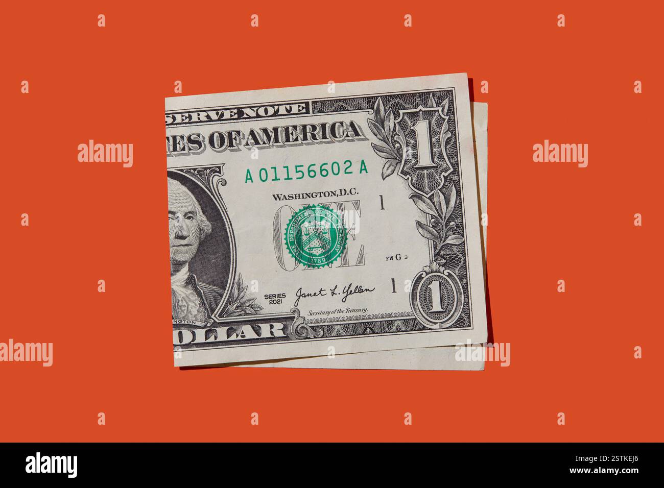 Plié un billet d'un dollar sur fond orange Banque D'Images