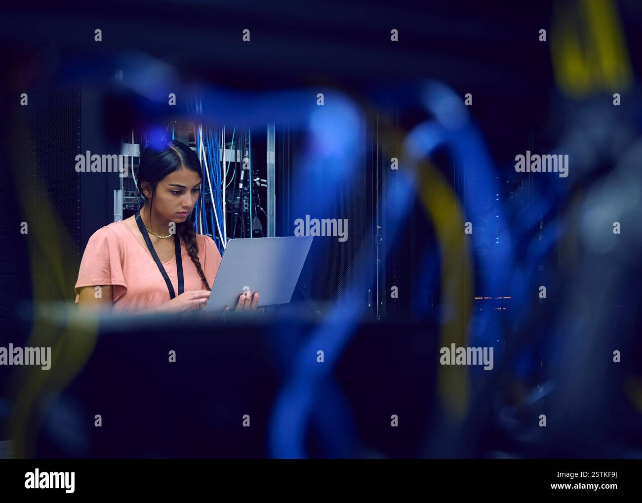 Femme technicien utilisant un ordinateur portable dans la salle des serveurs Banque D'Images