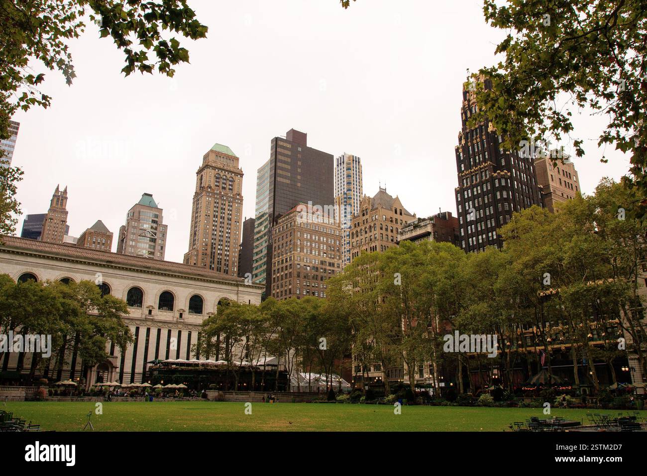 Une vue sur Bryant Park dans Midtown Manhattan, mettant en valeur sa pelouse verdoyante, ses arbres et l'architecture environnante. L'emblématique New York public Library est Banque D'Images