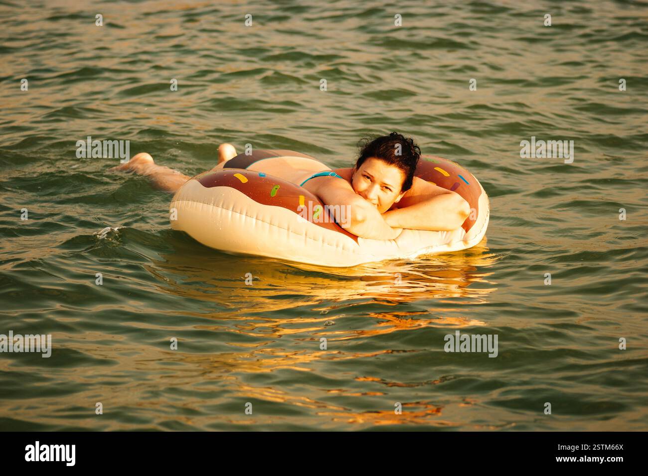 Femme reposant sur l'anneau gonflable dans la mer profitant des vagues douces chaudes et légères dans la station tropicale Banque D'Images