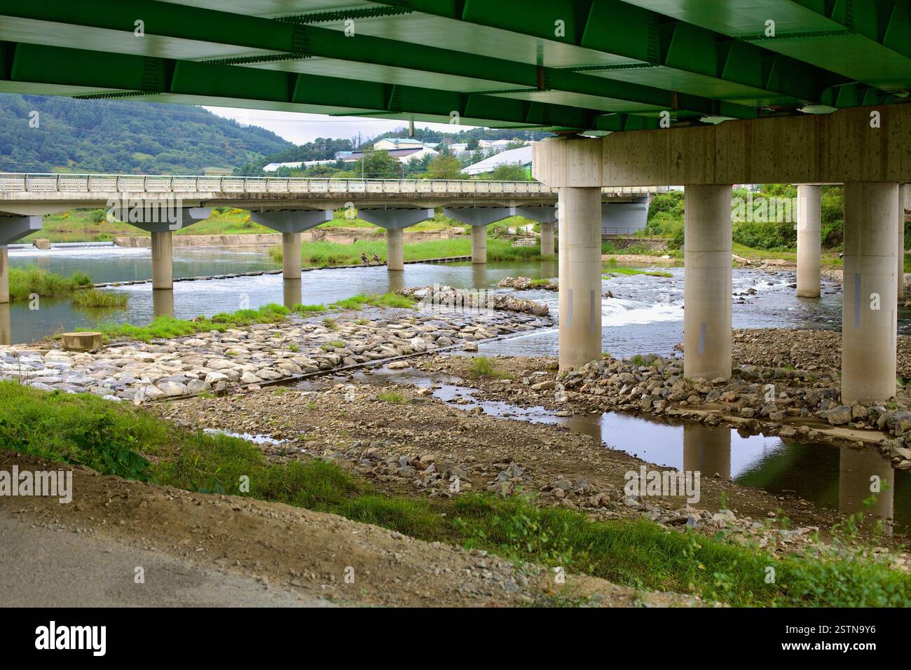 Comté de Goesan, Corée du Sud - 10 septembre 2020 : une vue de plusieurs ponts enjambant Seonghwang Stream, avec des cyclistes au loin et dans l'eau Banque D'Images