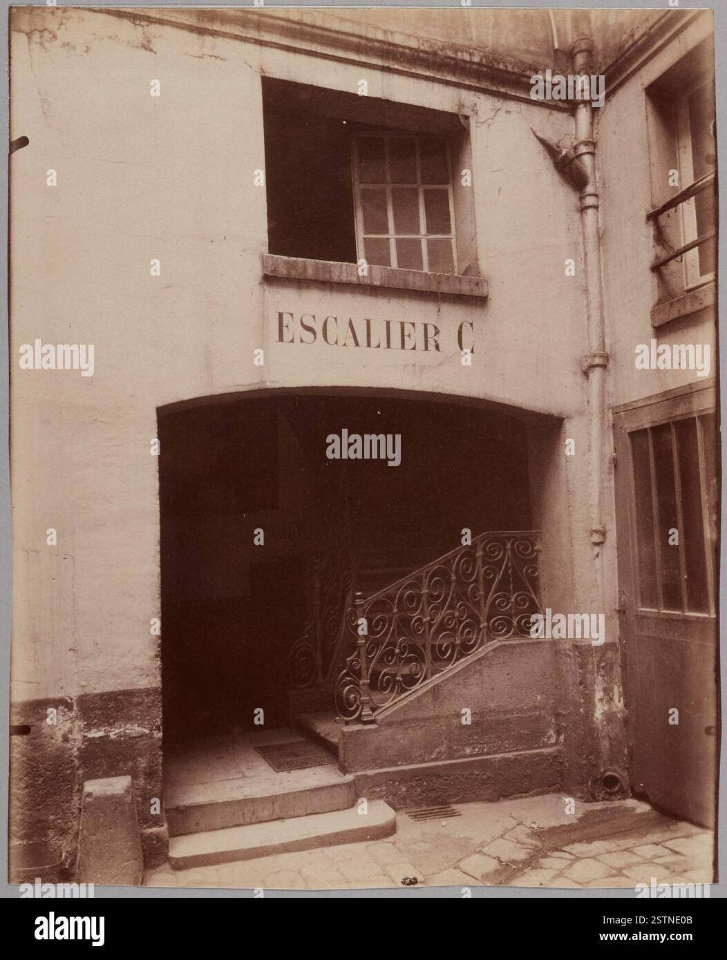 Eugène Atget (1857-1927), photographe français de renom, est connu pour son travail photographique pionnier sur les rues et l'architecture de Paris à la fin du XIXe et au début du XXe siècle. Cette photographie, acquise le 1er mars 1952, témoigne de sa maîtrise de la capture de paysages urbains et ruraux. Banque D'Images