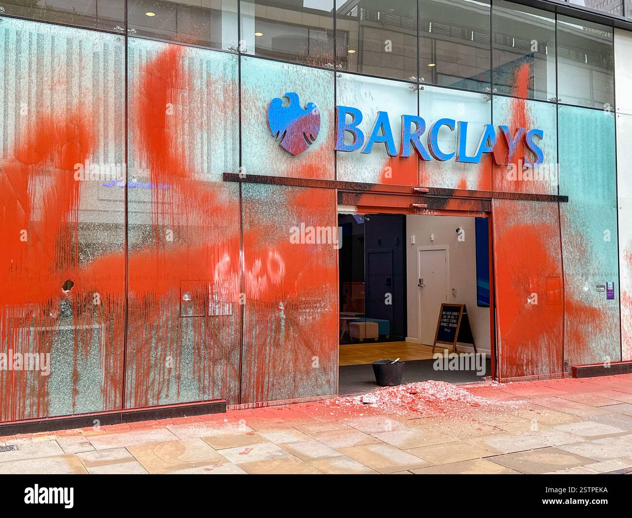 Manchester, Angleterre, Royaume-Uni - 31 mai 2024 : vue de face de la Barclays Bank dans le centre-ville de Manchester couverte de peinture orange lancée par des manifestants juste pétroliers - Image de stock capturée avec un smartphone