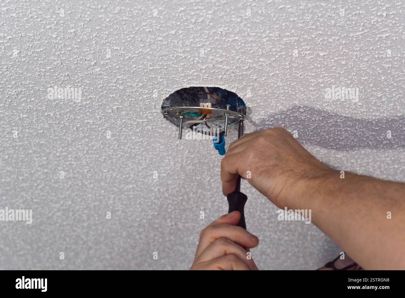 Gros plan mains de l'homme remplaçant le luminaire de plafond avec l'espace de copie Banque D'Images