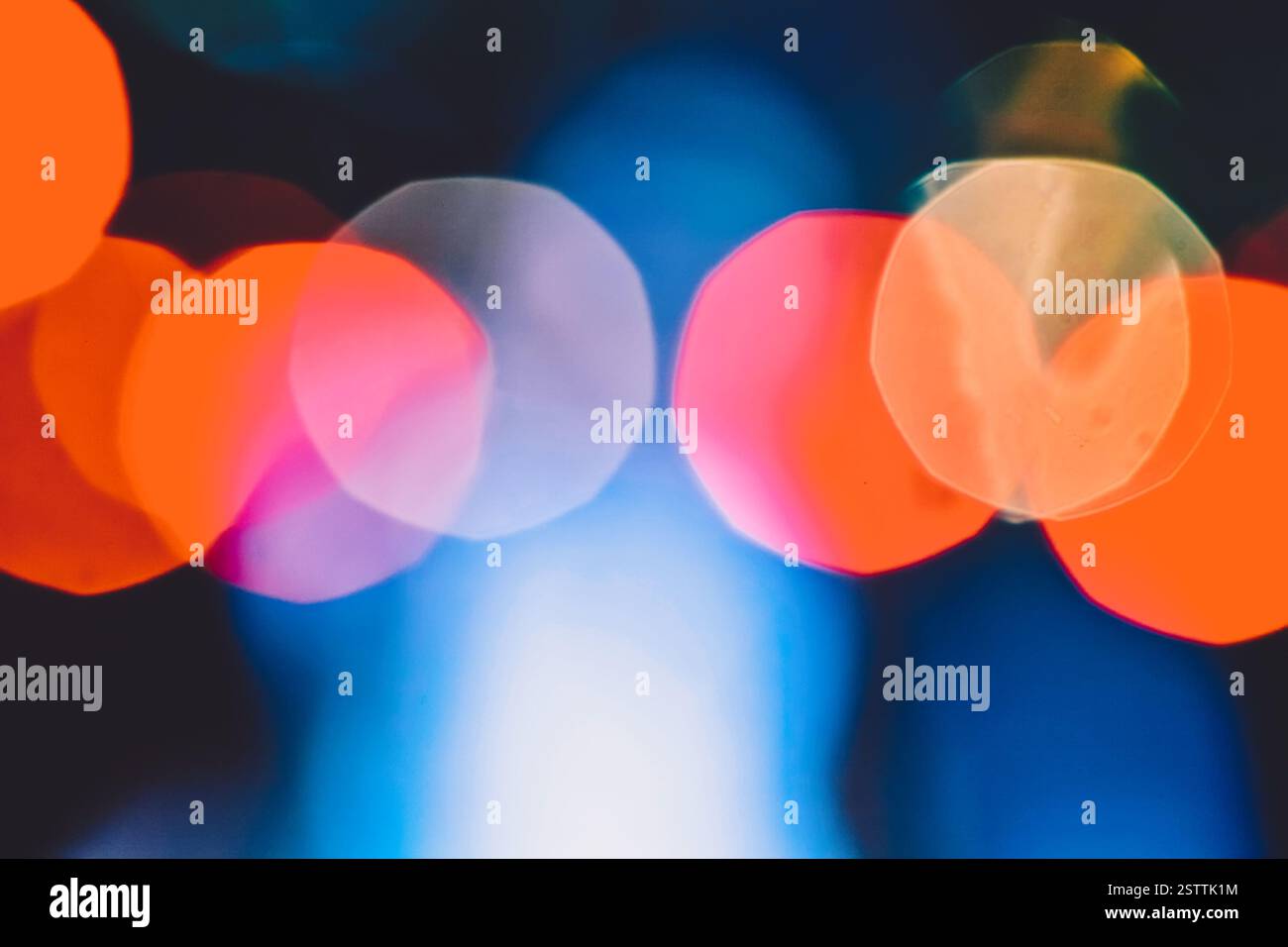 La nuit des lumières de rue de la ville bokeh. Les lumières de nuit floues se composent de taches rouges sur bleu profond. Banque D'Images