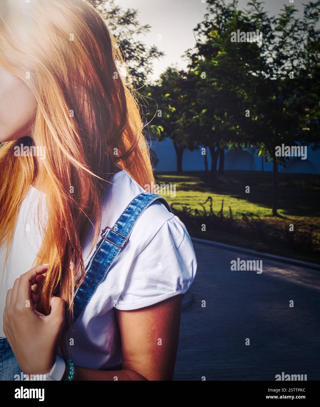 Dame blonde avec de longs cheveux posant dans le parc regardant loin, pas de tir de visage Banque D'Images