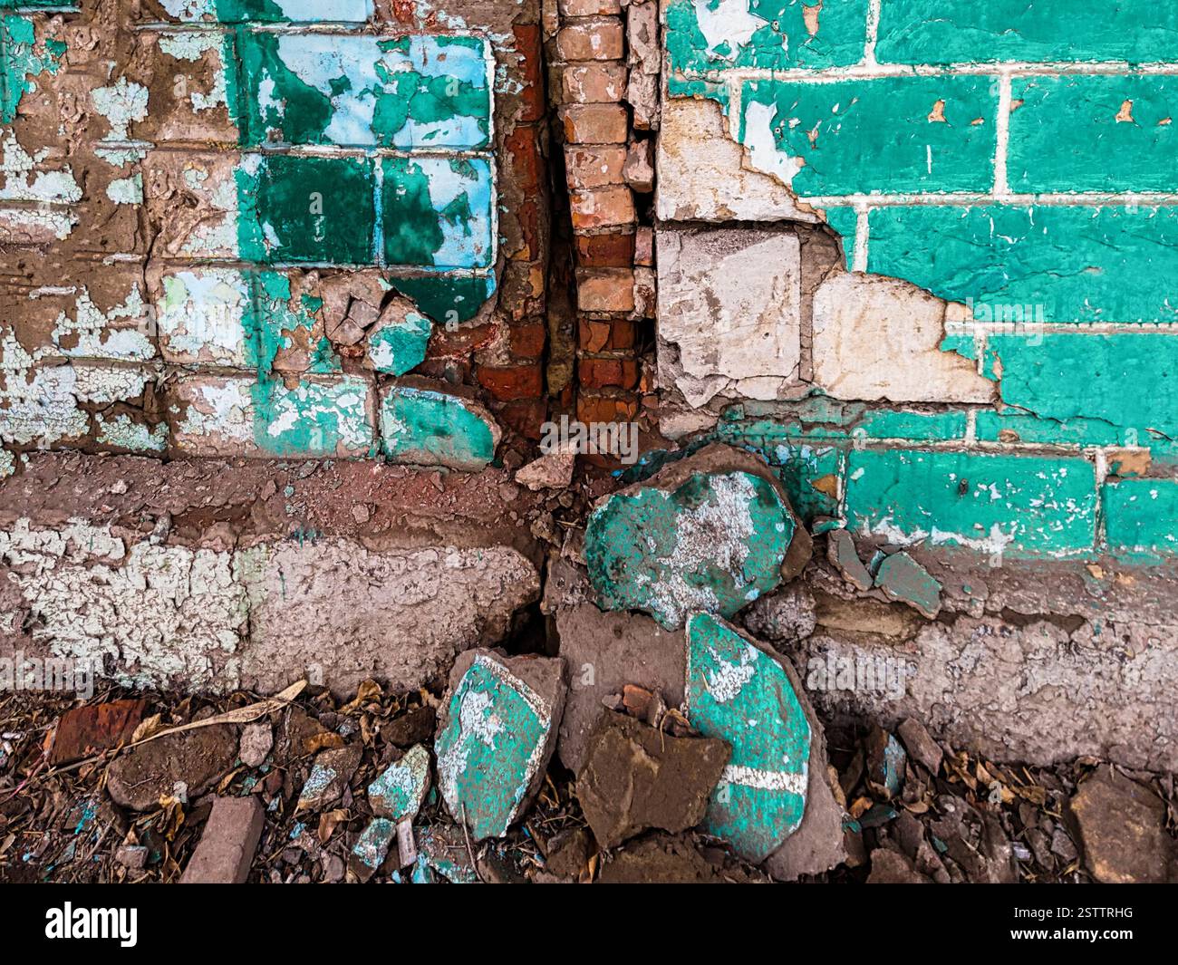 Vous pouvez voir les dommages graves à l'ancien mur de la maison avec de grands morceaux de plâtre tombant à proximité Banque D'Images