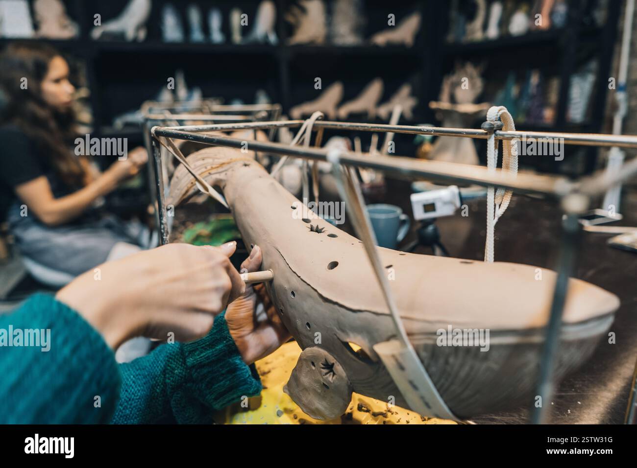 Les gens travaillent soigneusement sur les baleines en argile dans l'atelier Banque D'Images