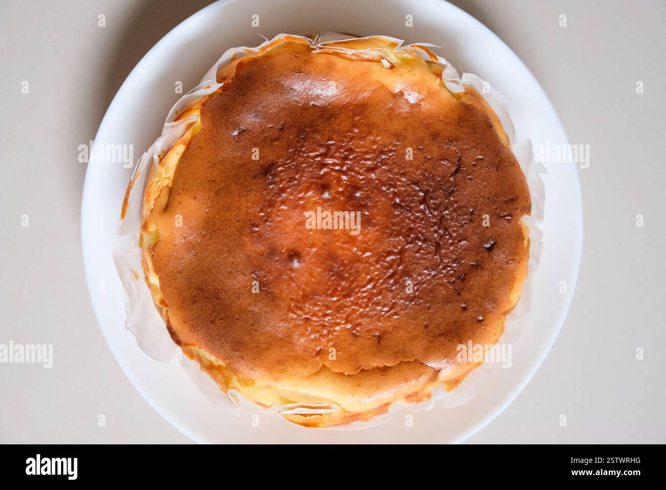 Gros plan de cheesecake basque brûlé maison sur une assiette blanche. Banque D'Images
