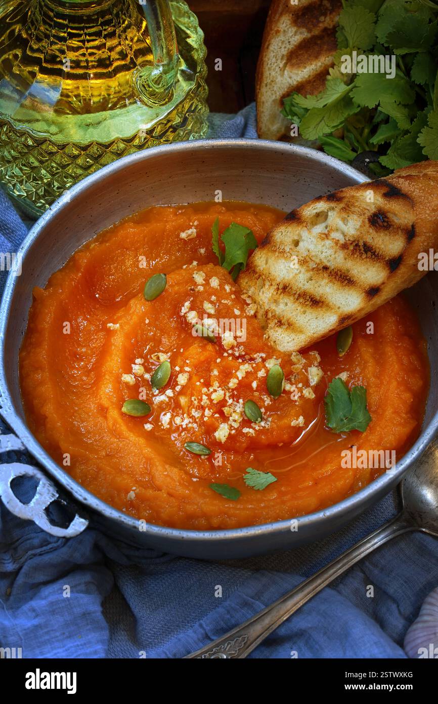 Soupe de purée de citrouille avec baguette grillée dans un plateau en bois Banque D'Images