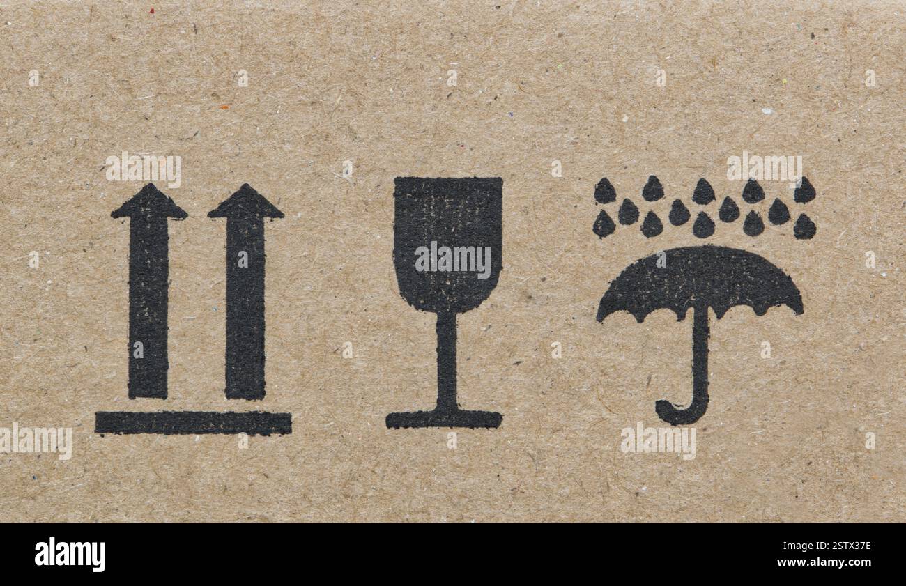 Les étiquettes d'avertissement sur la silhouette de la boîte en carton forment des flèches en verre de parapluie, cette façon vers le haut fragile garder sec instructions logistiques de transport. Banque D'Images