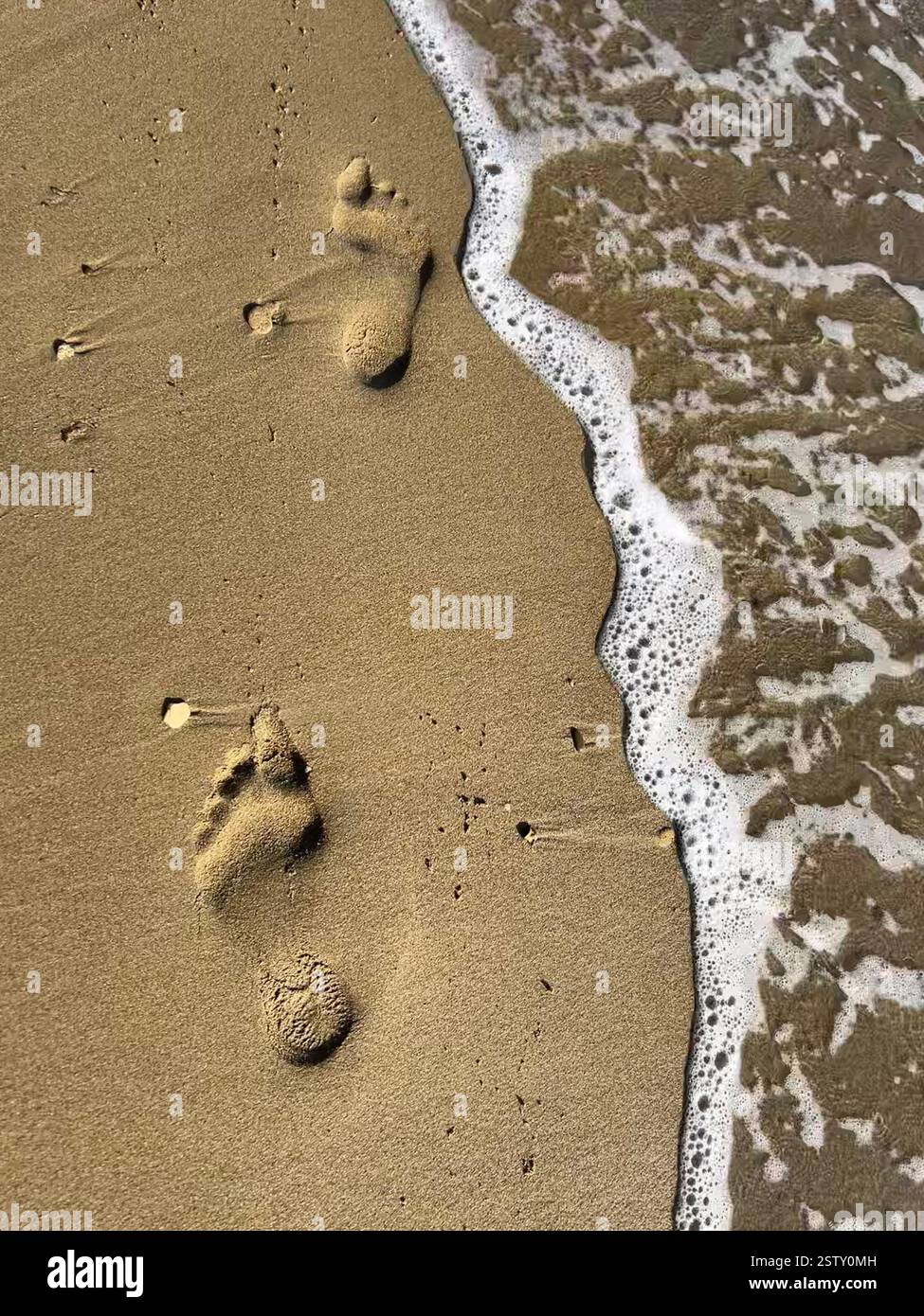 Traces d'un instant de pas laissés derrière - une histoire bientôt balayée par la marée! - Image de stock capturée avec un smartphone