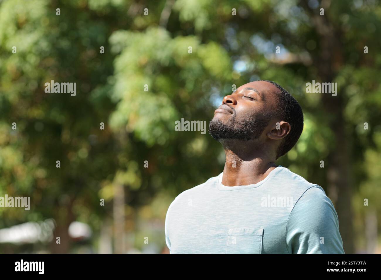 Homme noir respirant l'air frais sur le parc vert jour asunny Banque D'Images