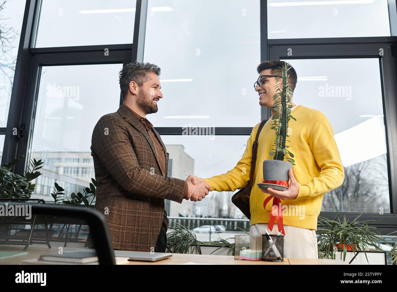 Le nouvel employé serre la main au manager, en montrant son enthousiasme lors de l'intégration dans un bureau lumineux. Banque D'Images