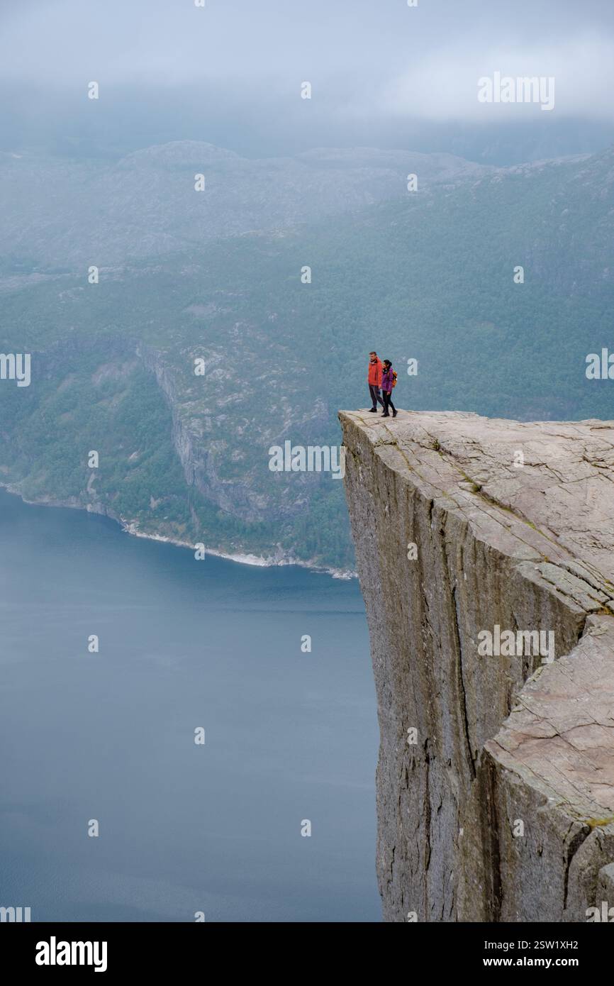 Grimpeurs sur Pulpit Rock surplombant le fjord dans Norways magnifique paysage de Preikestolen Banque D'Images