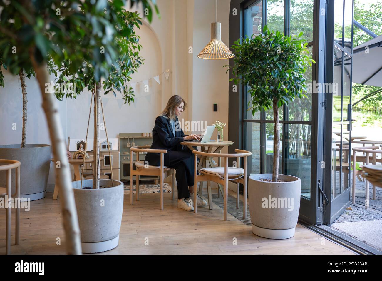 Femme d'affaires concentrée se concentrant sur le travail en utilisant l'ordinateur portable assis dans le café Banque D'Images