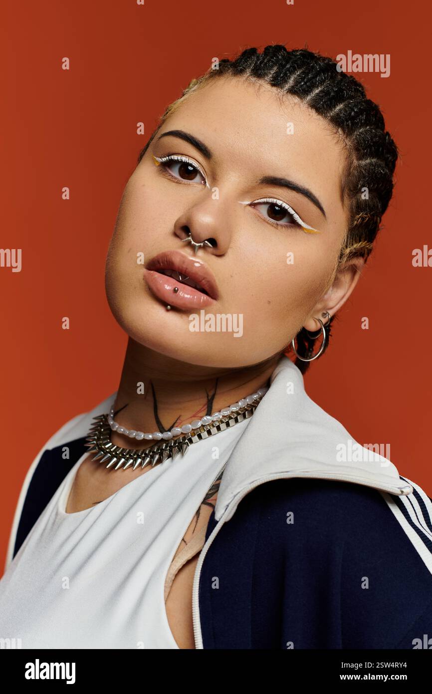 Une jeune femme confiante met en valeur son style unique avec des cheveux tressés et un maquillage saisissant. Banque D'Images