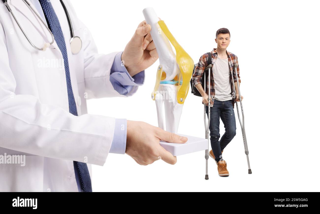 Étudiant masculin marchant avec des béquilles et médecin tenant un modèle d'os de genou isolé sur fond blanc Banque D'Images