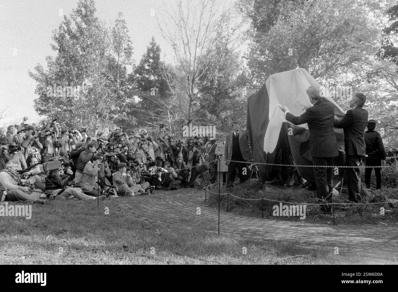 Les officiels lèvent la couverture de la statue des « trois combattants » du Vietnam Memorial lors de la cérémonie de dévoilement, le 9 novembre 1984 à Washington, D.C. de gauche à droite : Jan Scruggs, Vietnam Veterans Memorial Fund, Sen. John Warner, et l’artiste de casting Joel Meisner. Banque D'Images