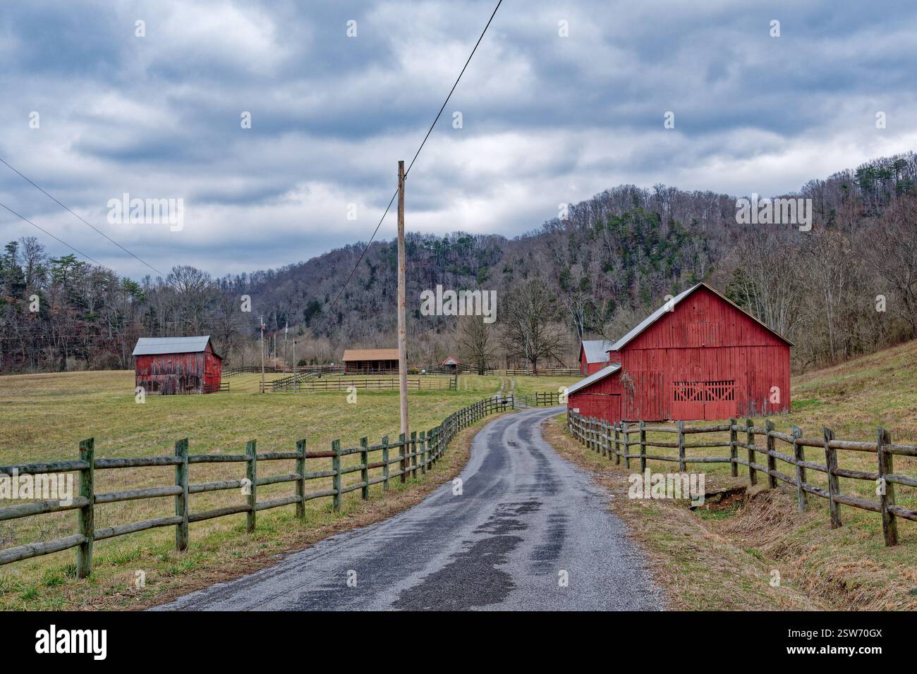Cadre de terres agricoles tranquilles dans les montagnes du Tennessee avec un couple de granges rouges vives clôturées dans les pâturages et une maison de chalet en rondins vue de la R Banque D'Images Cadre de terres agricoles tranquilles dans les montagnes du Tennessee avec un couple de granges rouges vives clôturées dans les pâturages et une maison de chalet en rondins vue de la R Banque D'Images