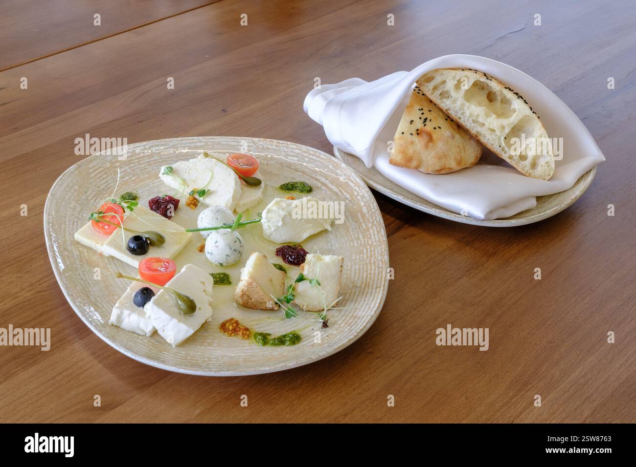 Une assiette de fromages assortis et un côté de pain plat l'apéritif parfait! Banque D'Images