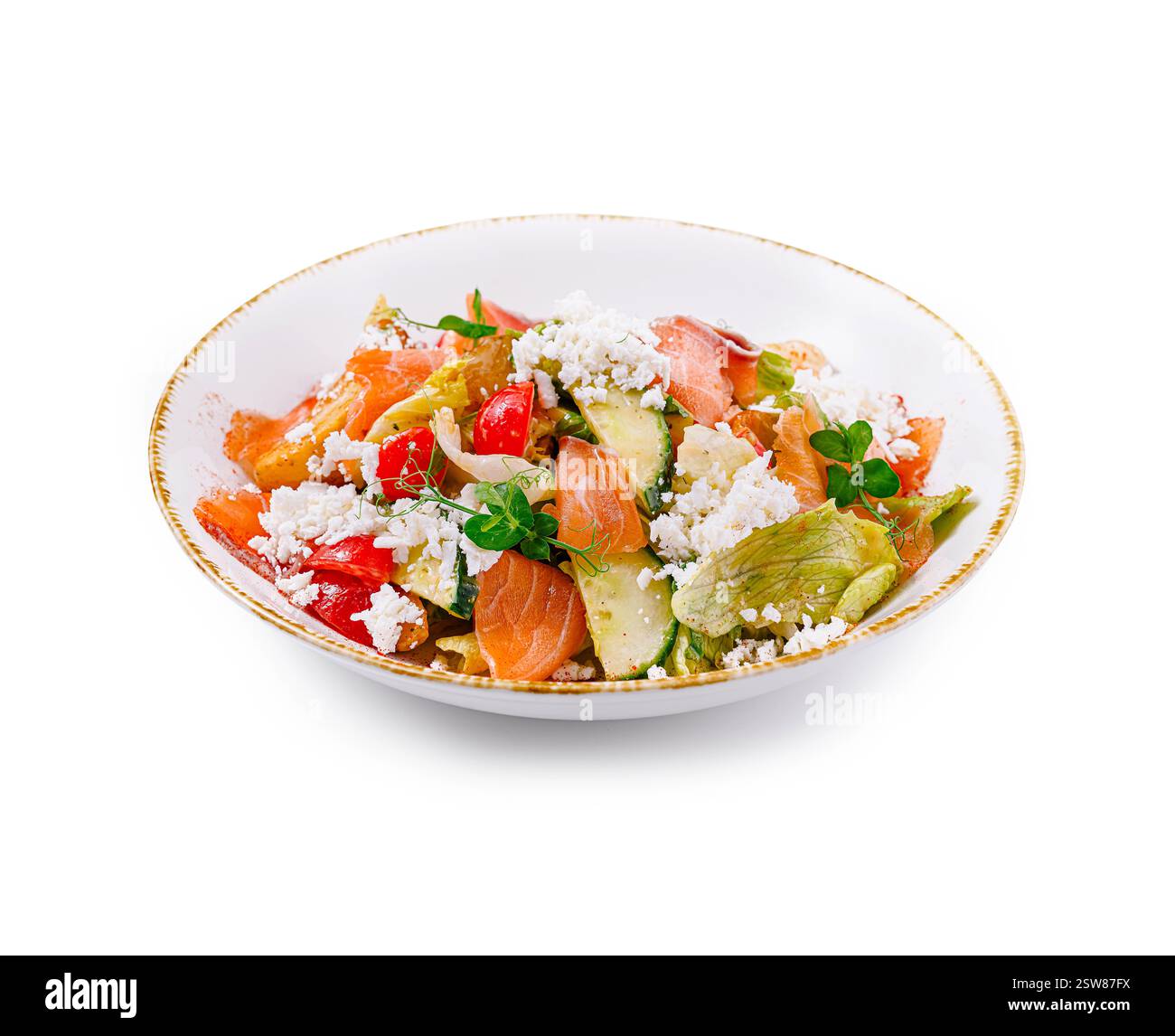 Délicieuse salade fraîche avec saumon et fromage feta sur assiette blanche Banque D'Images