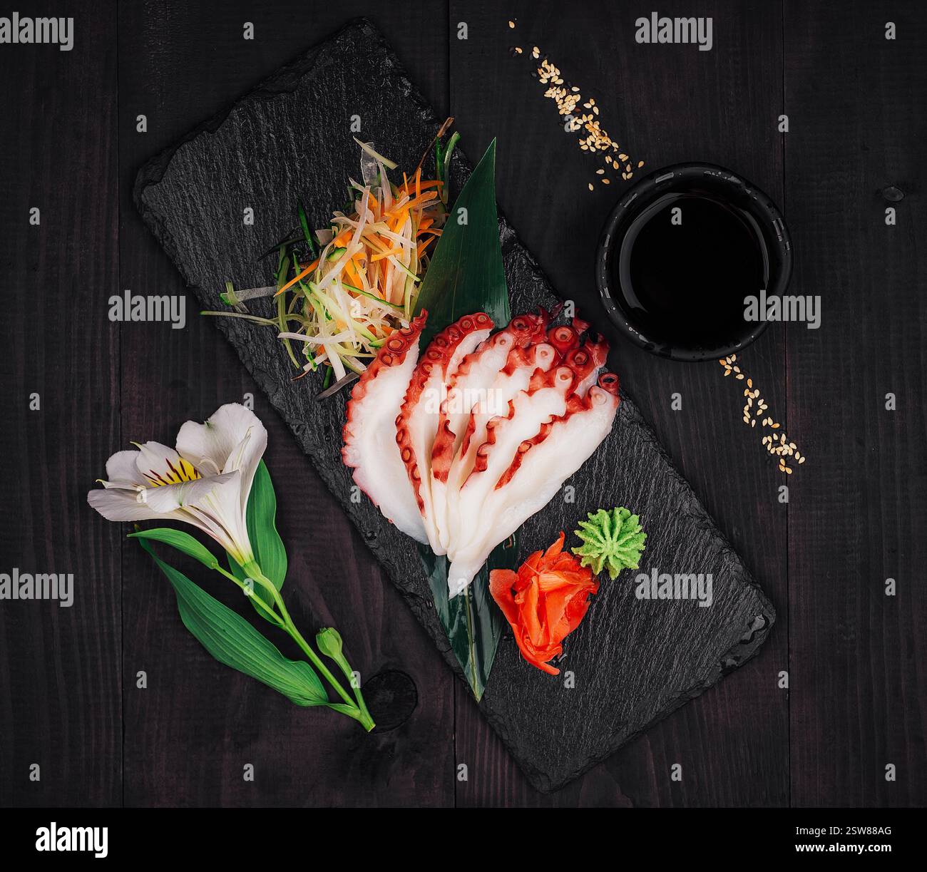 Sashimi de poulpe tranché avec sauce soja et wasabi sur un plateau de service en ardoise Banque D'Images Sashimi de poulpe tranché avec sauce soja et wasabi sur un plateau de service en ardoise Banque D'Images